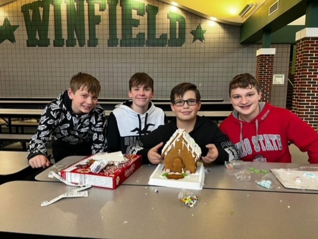 Students decorating gingerbread houses.